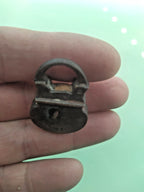 Miniature brass padlock held in fingers for scale – detail 9