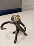 Bronze monkey salt and pepper holder with long curved arms and polished brass face