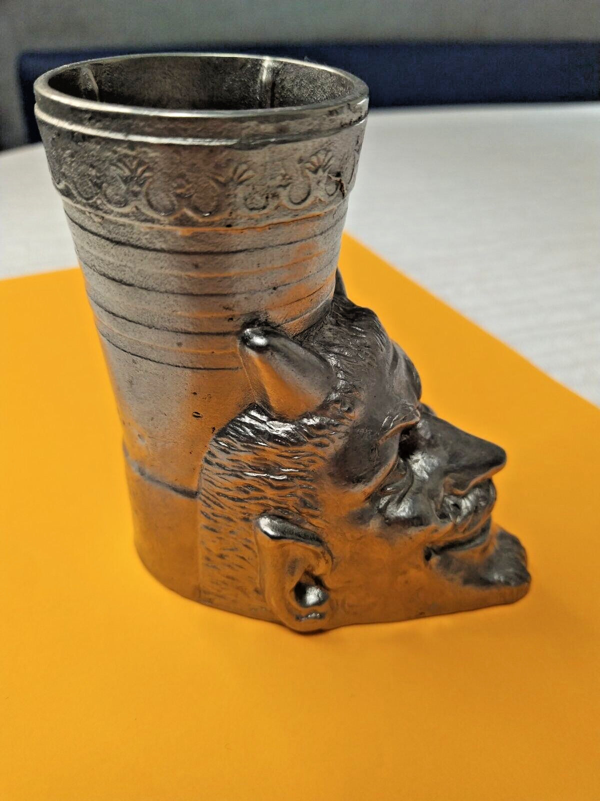 Horned smiling devil face on the cast metal desk decor