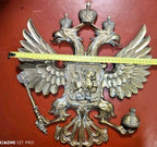 Heavy cast metal crest with mounting remnants on the reverse