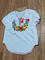Ukrainian embroidered blouse neckline with red tassels and cross-stitch