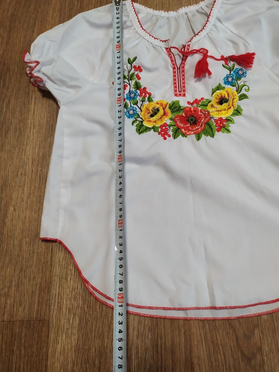 Ukrainian folk blouse laid flat with measuring tape