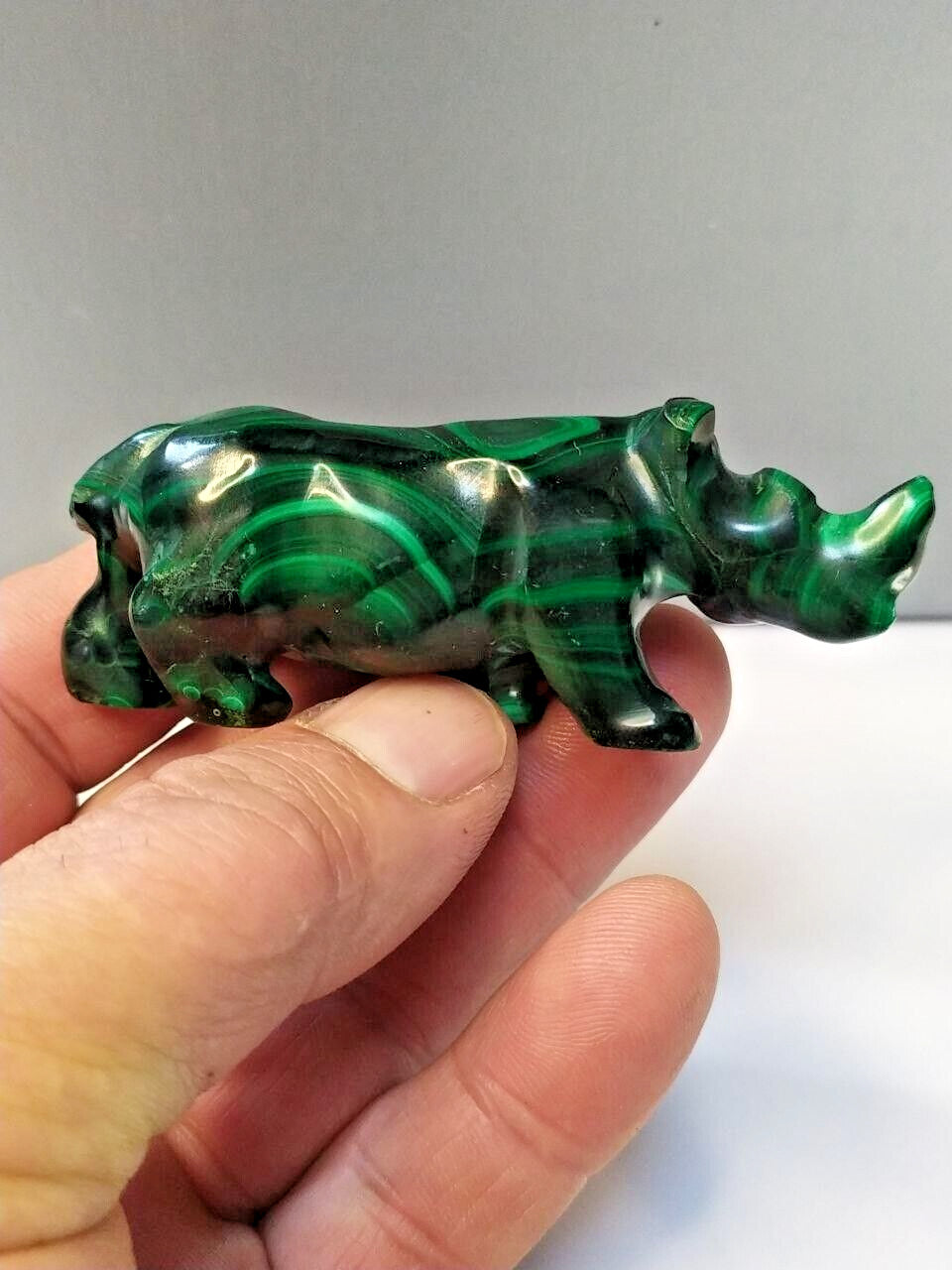 Natural malachite banding close-up on the carved rhinoceros – detail 10