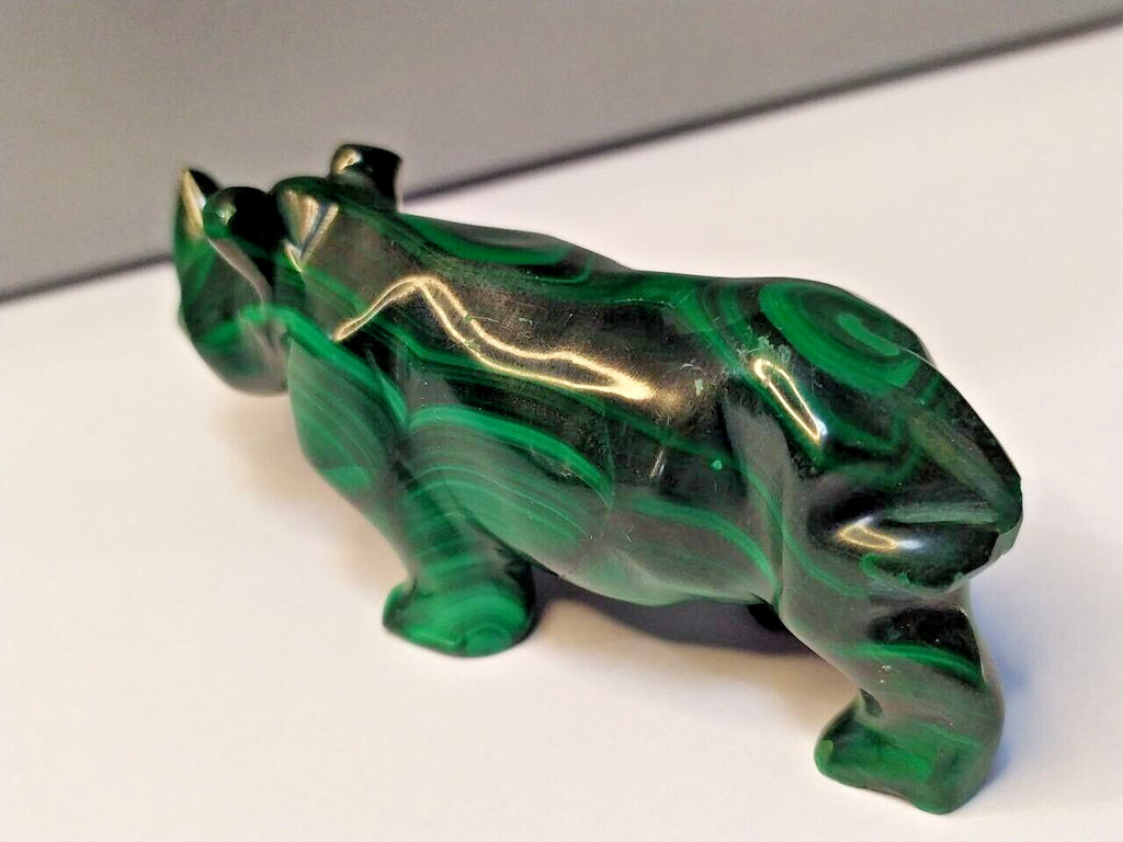 Green stone rhino figurine on a scale showing 106 g
