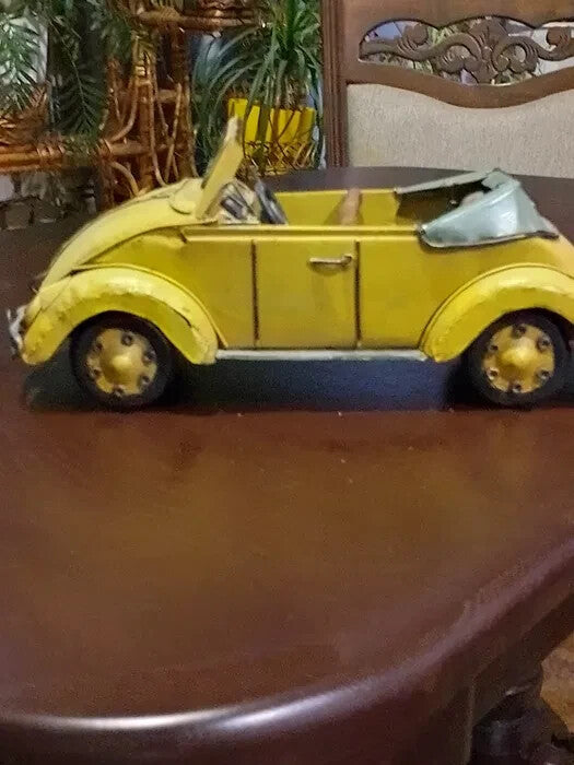 Yellow tin Beetle convertible model with exposed welds and hand-painted finish