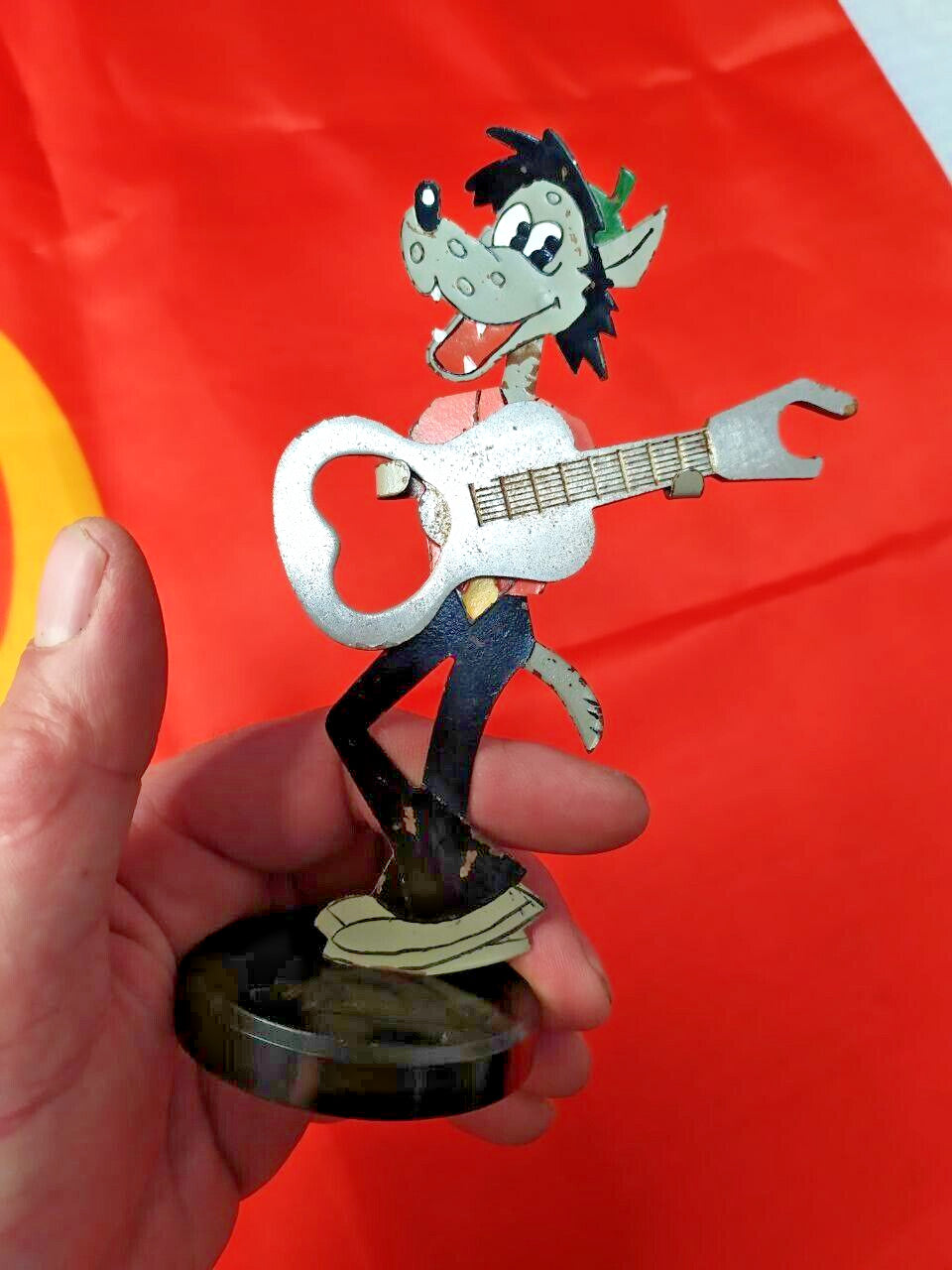 Nu Pogodi Wolf bottle opener figure holding a guitar on a black plastic base