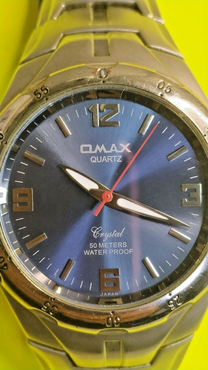 OMAX watch with luminous hands and bold numerals at 12, 3, 6 and 9