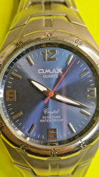 OMAX watch with luminous hands and bold numerals at 12, 3, 6 and 9