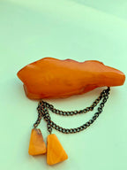Vintage amber jewelry brooch showing natural landscape patterns inside the stone
