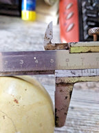 Old Soviet billiard ball next to a caliper showing about 67 mm diameter – detail 13