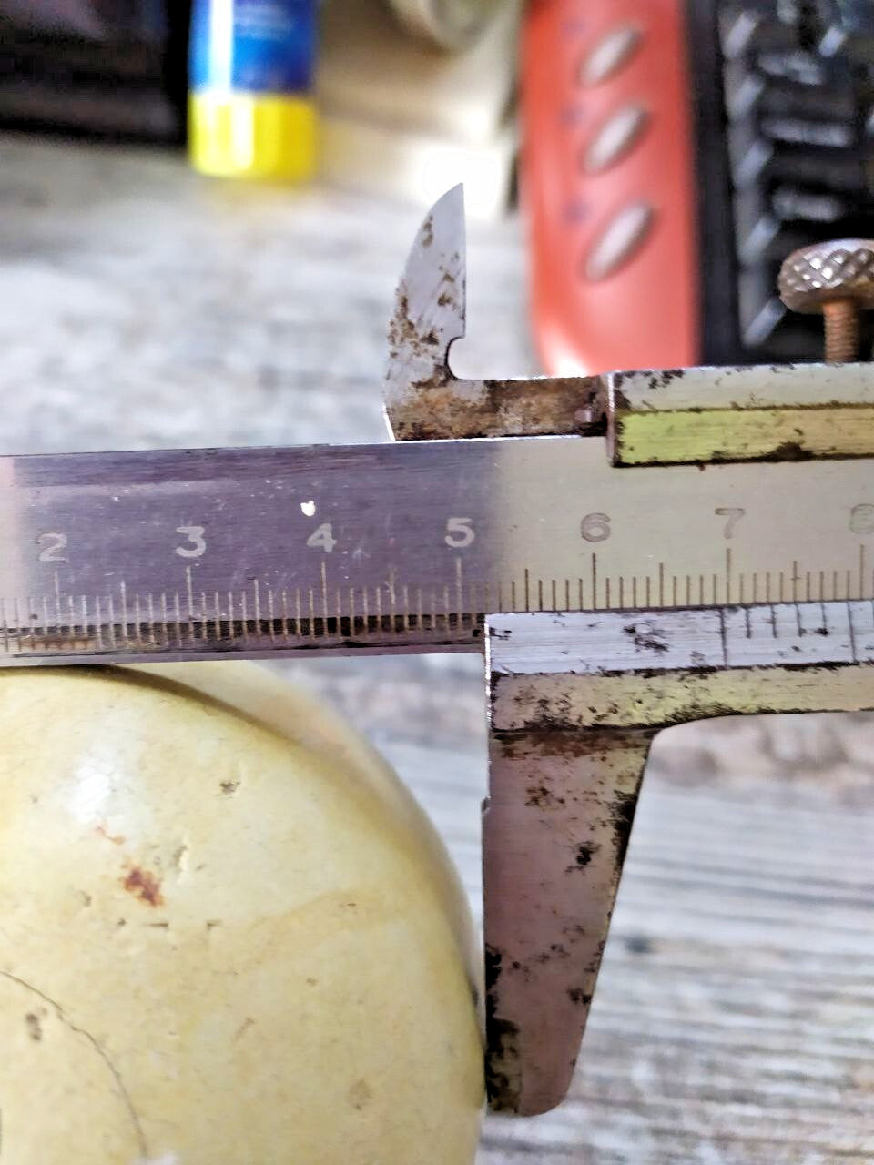 Old Soviet billiard ball next to a caliper showing about 67 mm diameter – detail 13
