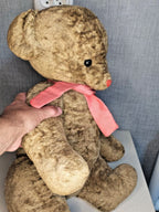 Soviet plush bear with pink ribbon around the neck standing upright