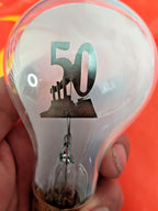 Vintage neon glow lamp lit with orange-red glow outlining a factory and the number 50
