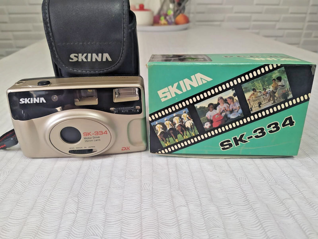 Boxed Skina compact film camera with three-position flash