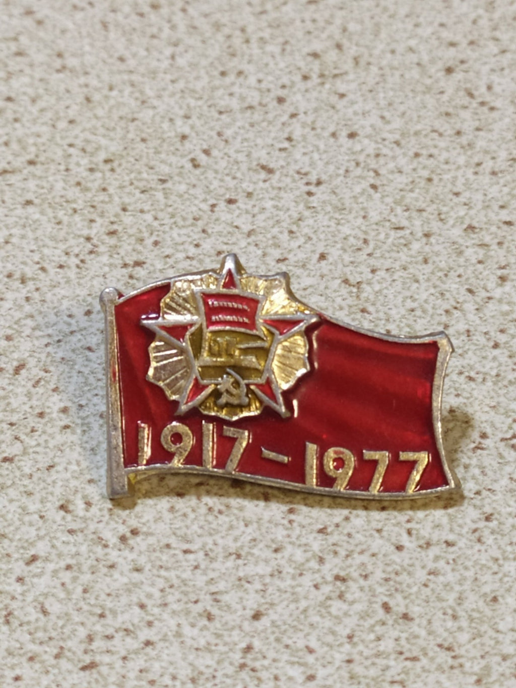 USSR flag badge dated 1917-1977 on a plain background