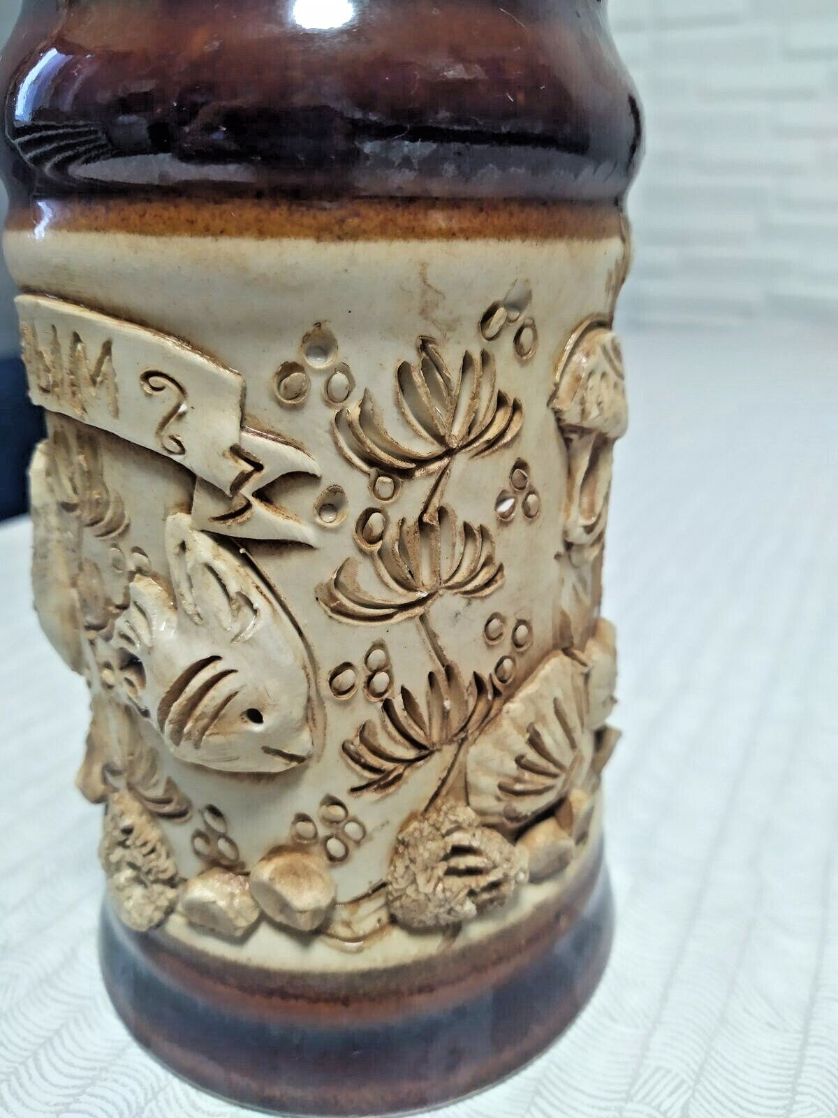 Relief decor of fish, shells and underwater plants on a ceramic mug