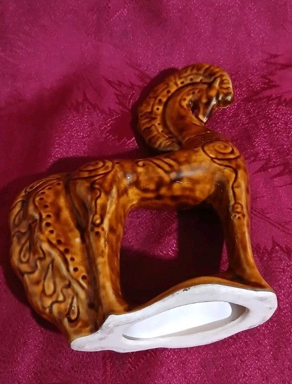 Ceramic horse figurine seen from the side with curved mane