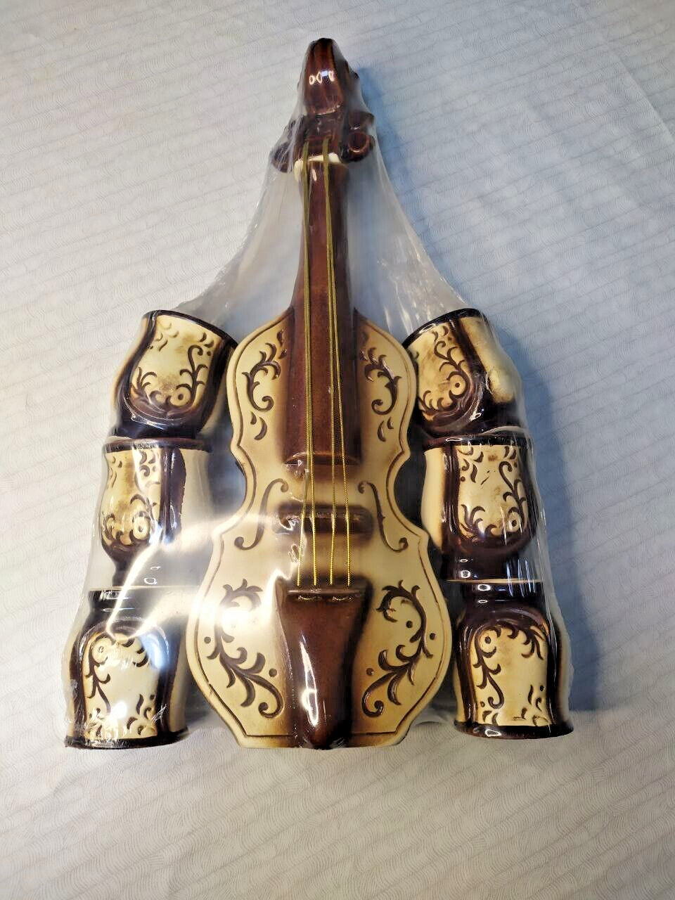 Ceramic decanter with cups fitted around the sides of the violin body