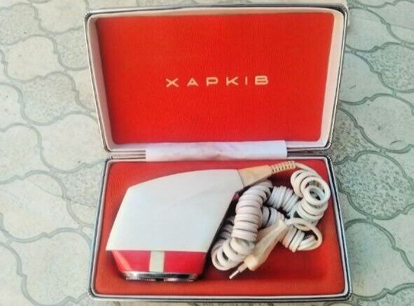 Soviet electric shaver Kharkiv-15 with red and white plastic body in its hard-shell case