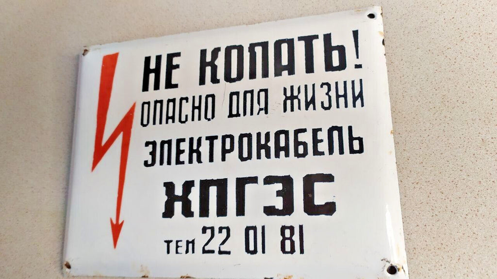 Enamel chips around the mounting holes of the Soviet warning sign