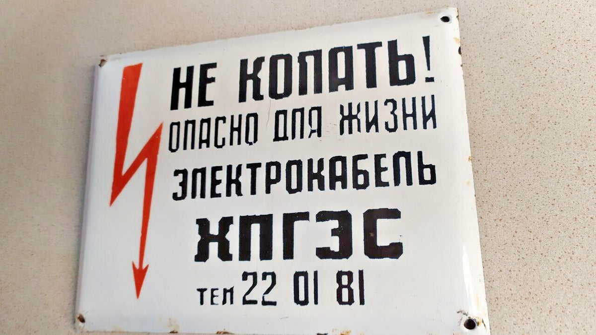 Enamel chips around the mounting holes of the Soviet warning sign