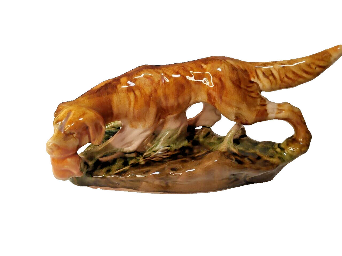 Soviet faience figurine of a setter hunting dog holding a game bird, brown drip glaze