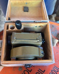 Soviet geodetic level MNP 1977 with olive hammer tone paint next to its wooden case