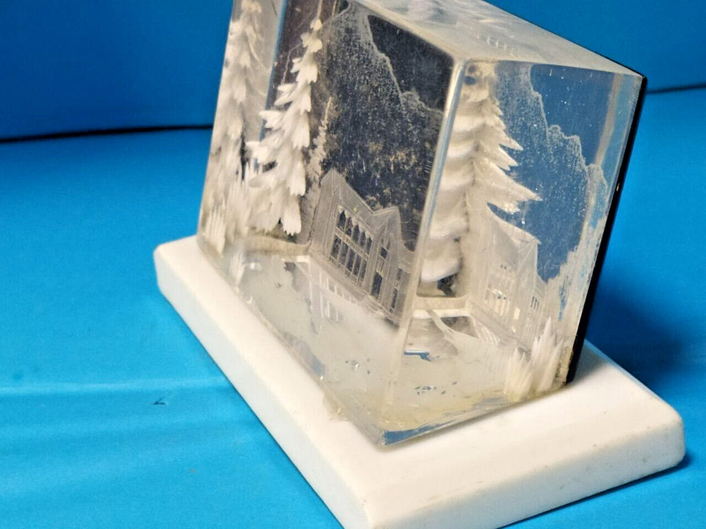 Soviet plexiglass souvenir on white rectangular base, side view