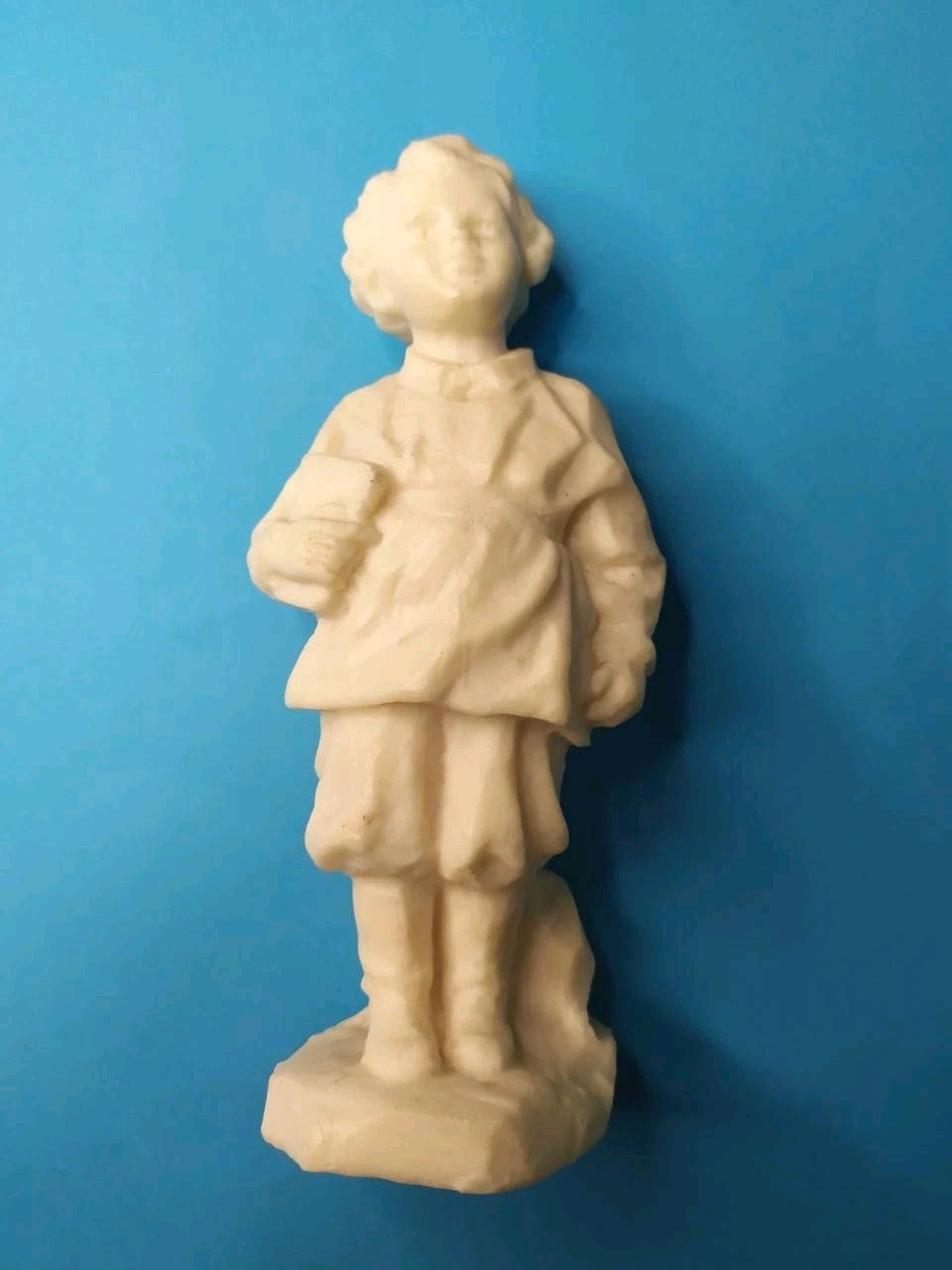 Young Lenin figurine shown next to a measuring tape