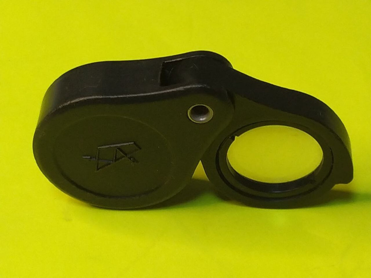 Folding pocket magnifier opened with clear glass lens swung out