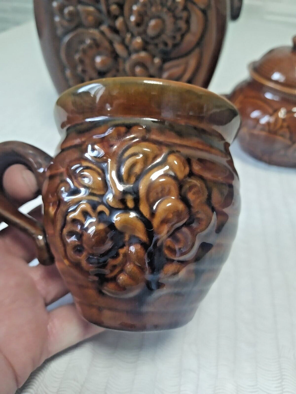 Chocolate-brown majolica cup with raised floral pattern