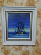 Tall ship painting in white wooden frame with gold inner rim