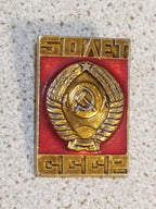 Gold-tone Soviet emblem pin with red enamel and 50 Years inscription