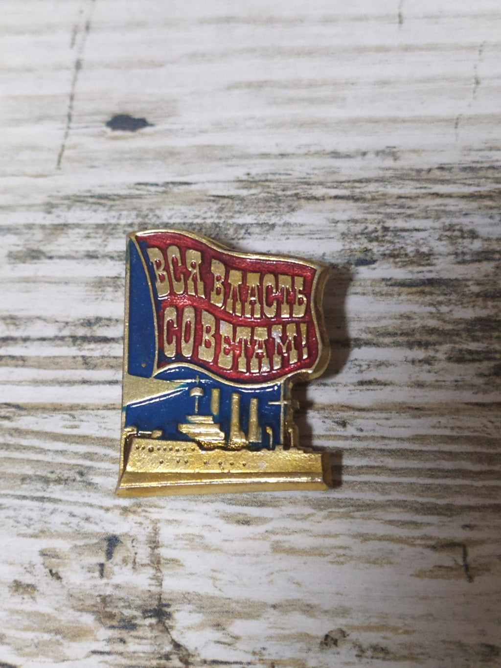 Soviet propaganda badge with revolutionary slogan and Aurora cruiser