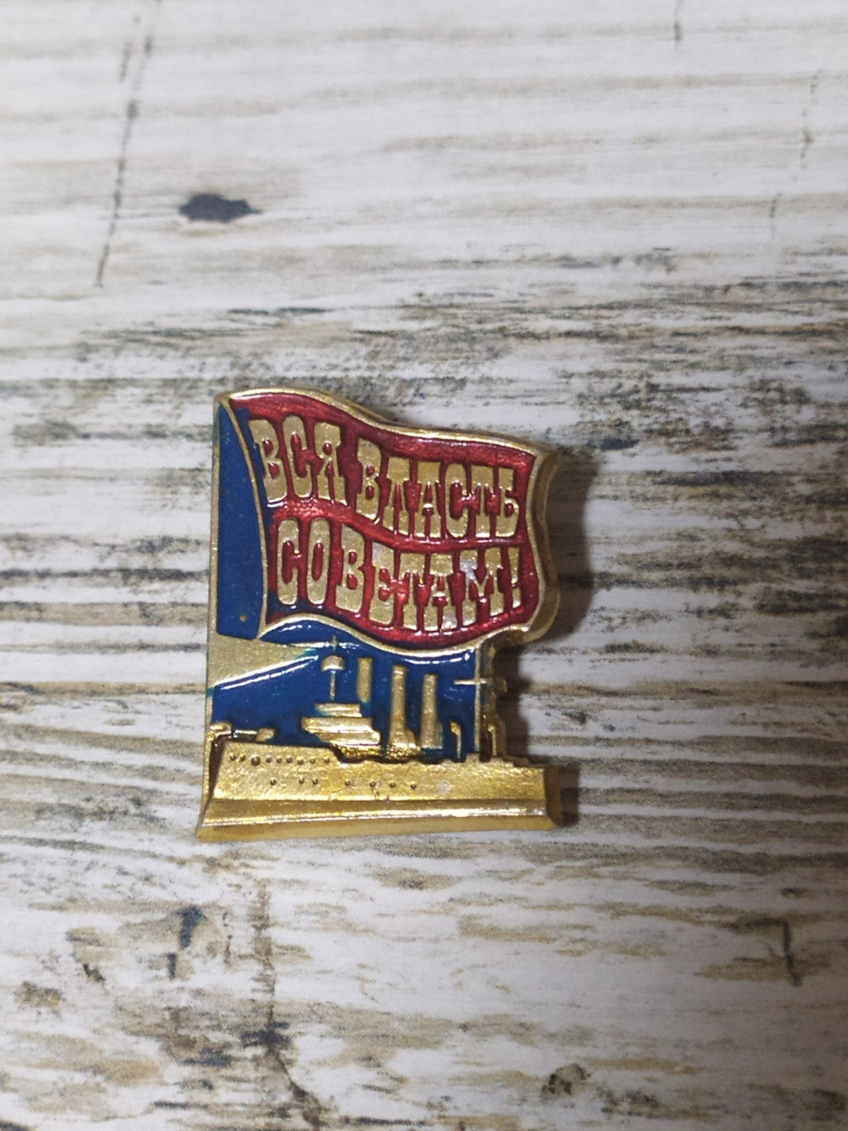 Soviet propaganda badge with revolutionary slogan and Aurora cruiser