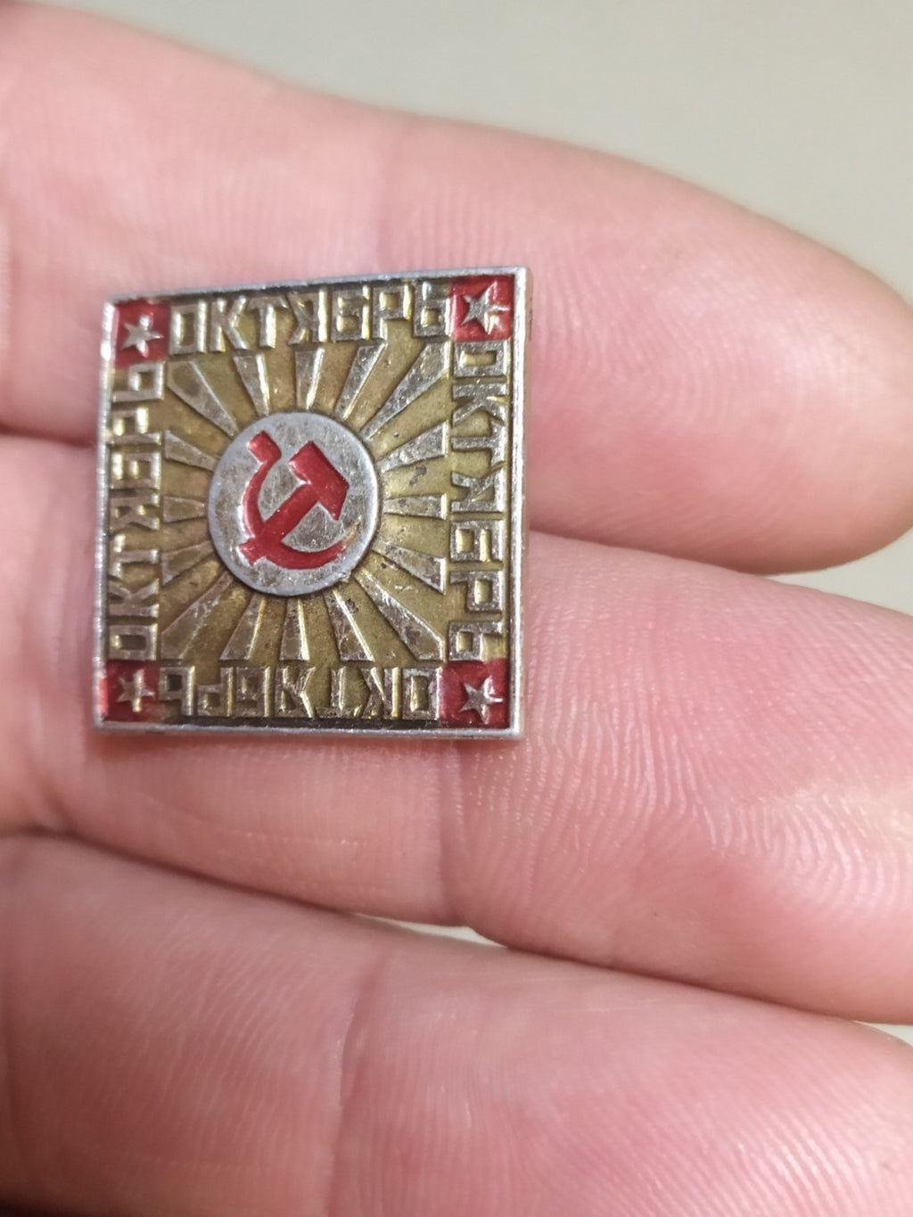 Square USSR badge with hammer and sickle, close view