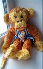 Old Soviet toy monkey in striped vest, side view