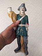 Porcelain soldier figurine in dark green uniform with gold accents and tricorne hat