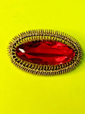 Soviet brooch in gilded silver 916 with a large red marquise-cut stone and filigree halo