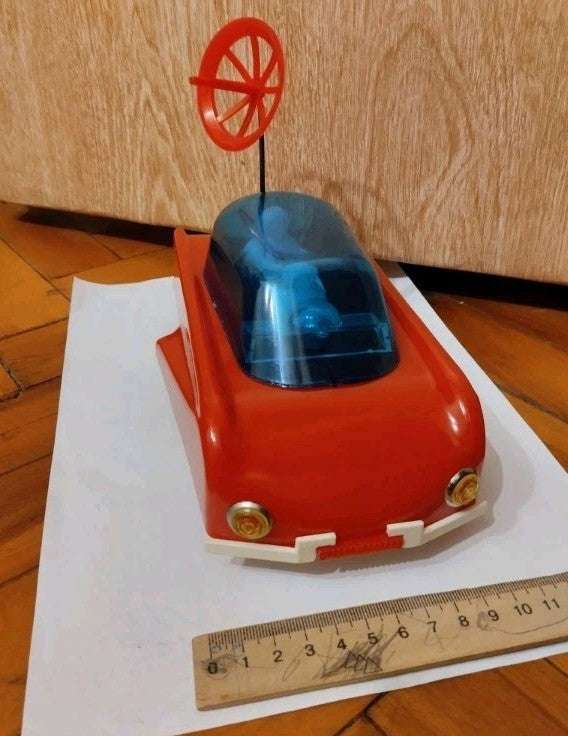 Old Soviet toys collectible space car next to a ruler, approx. 22.5 cm long