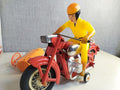 Soviet tin toy motorcycle with plastic rider in yellow jumpsuit and orange remote control