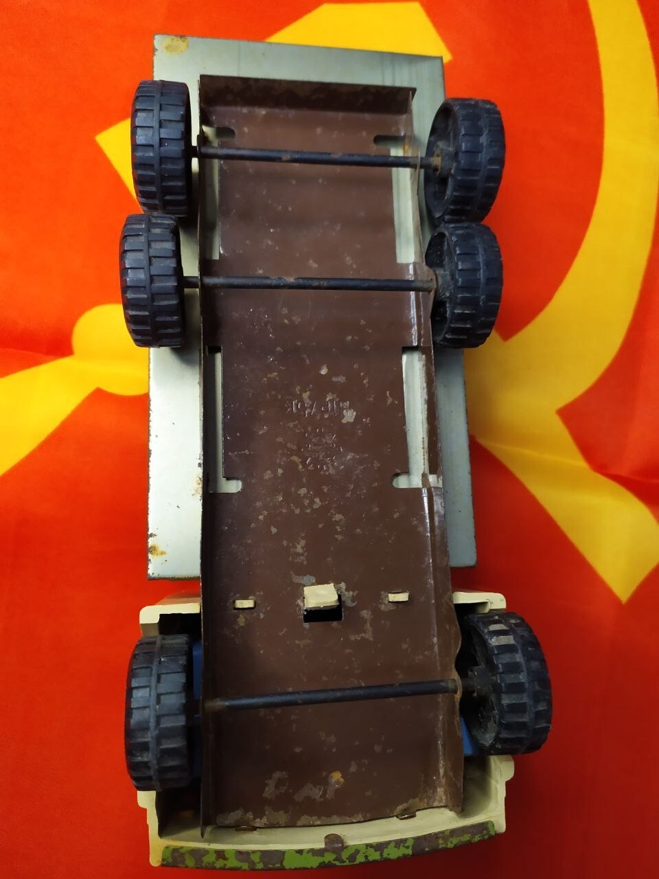 Old Soviet toy truck showing play wear, rust and paint loss on the tin bed – detail 8
