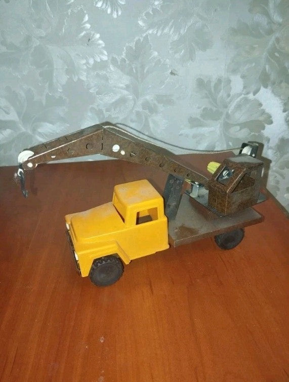 Vintage Soviet toy crane truck with yellow plastic cabin and brown metal crane