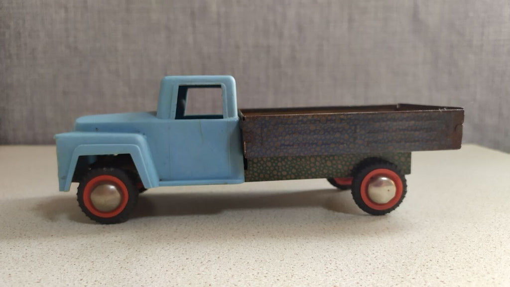 Old Soviet tin toy truck side view showing rolling wheels
