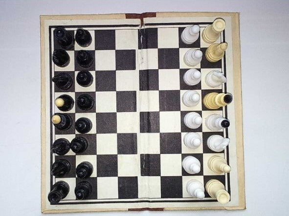 Vintage Soviet pocket chess pieces in black and cream plastic