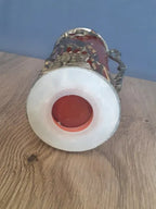Ruby red art glass vase beside a light source