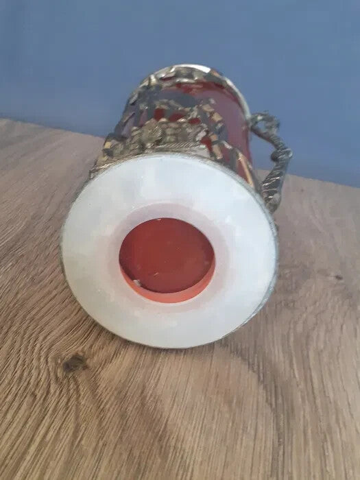 Ruby red art glass vase beside a light source