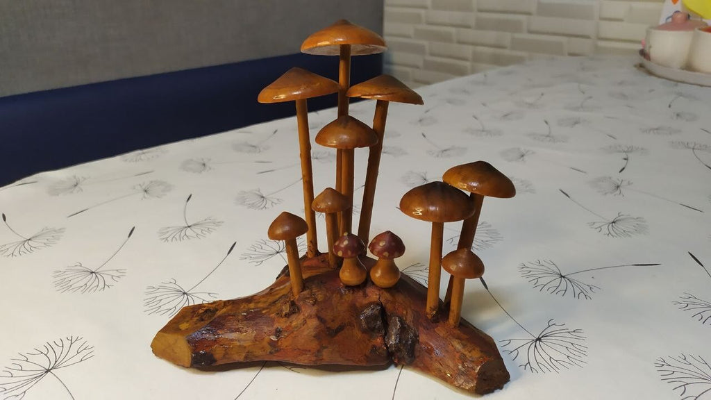 Varnished carved wooden mushrooms growing from a driftwood root base
