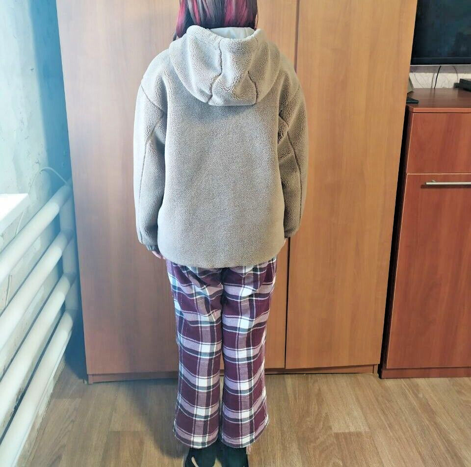 Kids teddy coat laid flat with measuring tape across the chest
