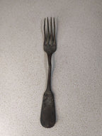 Antique Russian copper alloy dinner fork on a scale showing 67 grams
